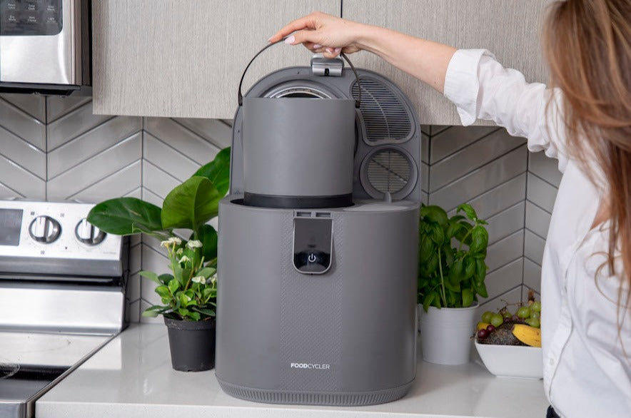 Person placing their bucket into the FoodCycler Eco 5 - Grey